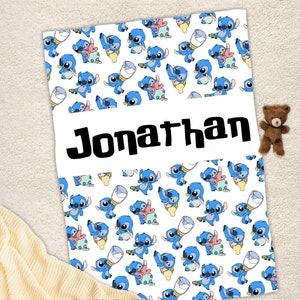 May include: A white blanket featuring a repeating pattern of blue alien characters holding baby bottles and wearing diapers, with the name Jonathan printed in large black letters across a central horizontal white band on the fabric.