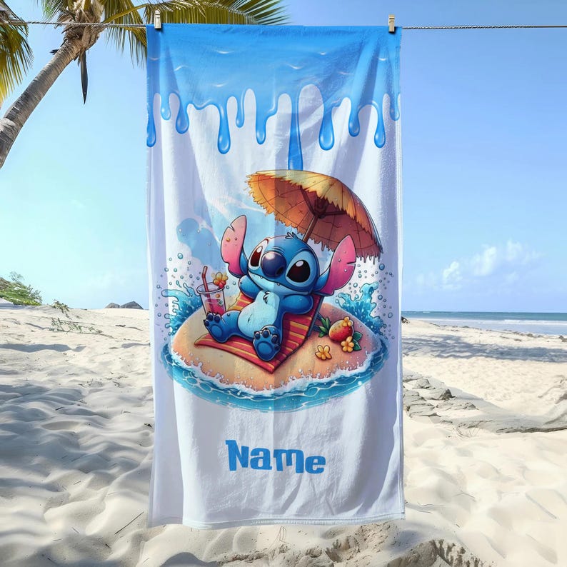 May include: White beach towel featuring a cartoon character relaxing on a tropical island. The blue and white towel has a blue border with dripping water design. The character is under a brown umbrella, with a drink in hand, and the word "Name" in blue.