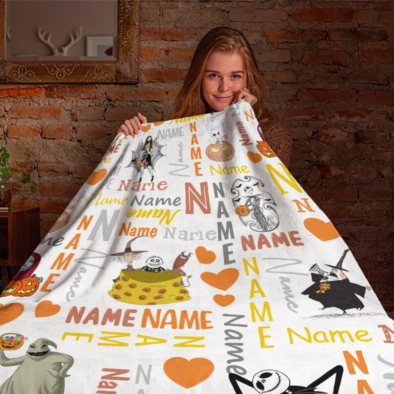 May include: A white fleece blanket featuring a repeating pattern of characters from The Nightmare Before Christmas, including Jack Skellington, Sally, and Oogie Boogie, interspersed with orange hearts and the word Name in various fonts and colors.