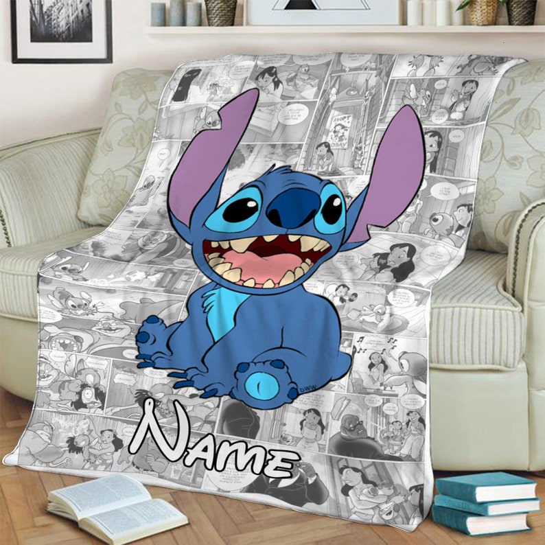 May include: A soft throw blanket featuring a large, blue, alien character with long ears and a wide grin centred over a black and white comic book panel collage. The word "Name" is printed in a bold, white, outlined font at the bottom.