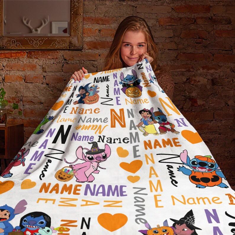 Może przedstawiać: Biały koc z polaru z powtarzającym się wzorem postaci Stitcha i Lilo w kostiumach na Halloween, pomarańczowymi sercami oraz słowem Name wydrukowanym r&oacute;żnymi czcionkami, rozmiarami i kolorami, w tym pomarańczowym, fioletowym i czarnym.