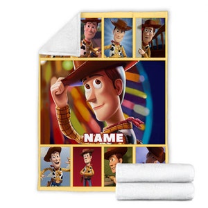 May include: A soft fleece blanket featuring multiple panels of the character Woody from Toy Story. The central image shows Woody tipping his brown cowboy hat, with the word NAME printed in white block letters. The blanket has a white underside.