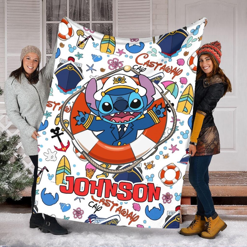 May include: A white fleece blanket with a colourful cartoon design featuring Stitch from Lilo & Stitch. The blanket has a blue and white striped background with a red life preserver and the text "Castaway Cap'n Johnson".