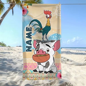 May include: A rectangular beach towel featuring a cartoon rooster standing on a white piglet holding a bowl of food. The background includes tropical flowers, a sun, and geometric patterns. The word NAME is printed vertically in dark blue letters.