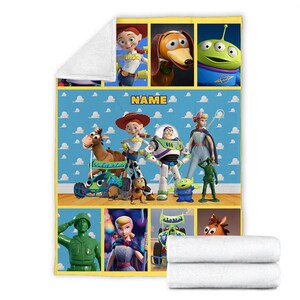 以下が含まれることがあります： トイストーリーの映画フランチャイズのキャラクターが描かれたカラフルな毛布。毛布は、ウッディ、バズ・ライトイヤー、ジェシー、スリンキー・ドッグ、その他のキャラクターの画像のコラージュになっています。毛布は黄色で、青い背景に白い雲があります。毛布の中央には「NAME」という文字があります。