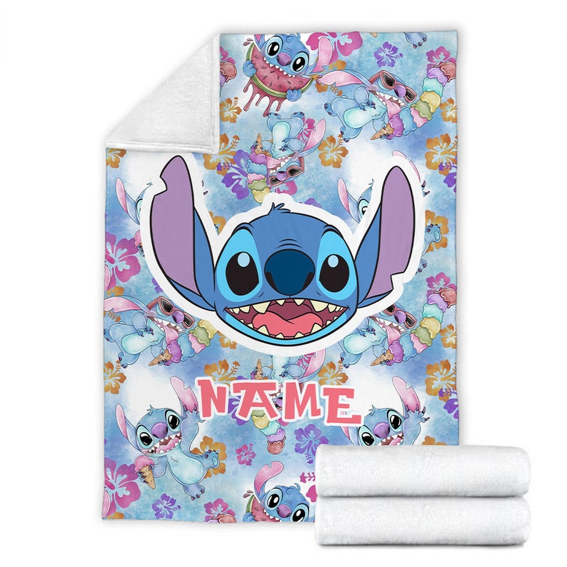 Puede incluir: Una manta de forro polar suave con un patr&oacute;n repetitivo del personaje azul Stitch, flores de hibisco tropicales y helados. Un gr&aacute;fico central grande muestra la cara del personaje, con la palabra NAME impresa en letras rosas.