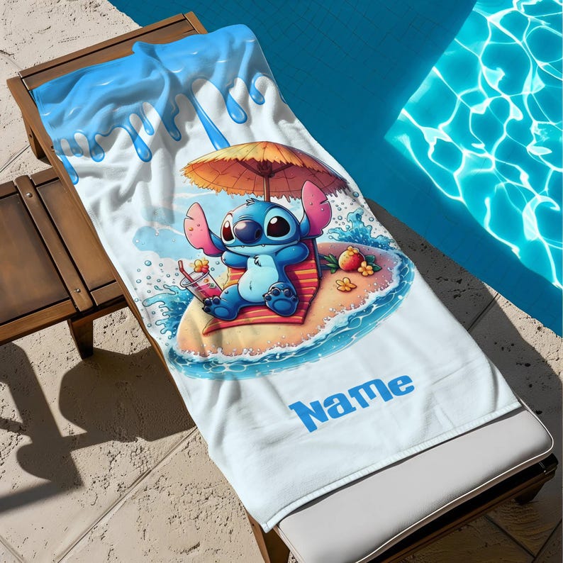 May include: A white beach towel featuring a cartoon character relaxing on a beach with an umbrella. The towel has a blue and white water design at the top and the word "Name" in blue at the bottom.