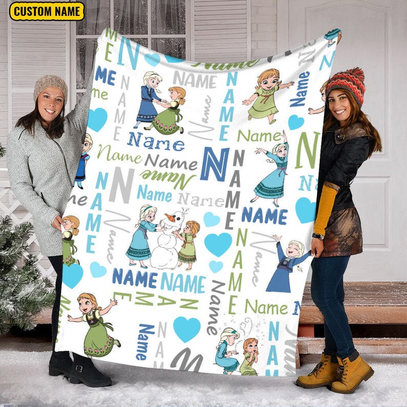 May include: A white fleece blanket featuring a repeating pattern of cartoon characters Elsa and Anna, blue hearts, and the word Name in various fonts and colors including blue, green, and gray. The top left corner displays the text CUSTOM NAME.
