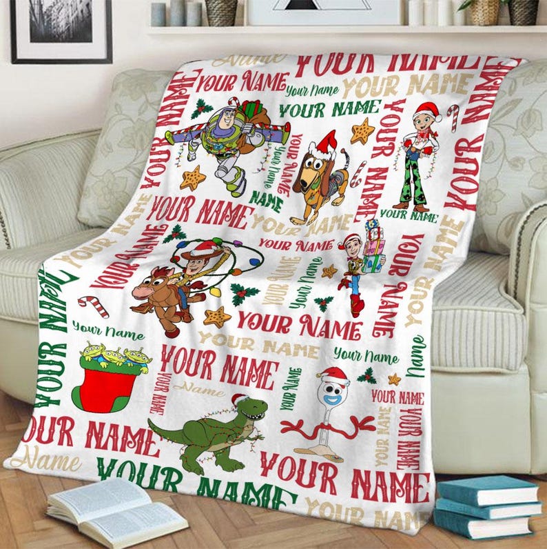 May include: White fleece blanket with a Christmas theme featuring Toy Story characters. The blanket has a repeating pattern of the characters and the words "Your Name" throughout.