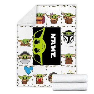 May include: A white fleece blanket featuring a repeating pattern of green alien characters in various poses, including one in a box labeled Adopt this JEDI, one with a pink bow, and one holding a blue balloon. A large black rectangle displays the word NAME.