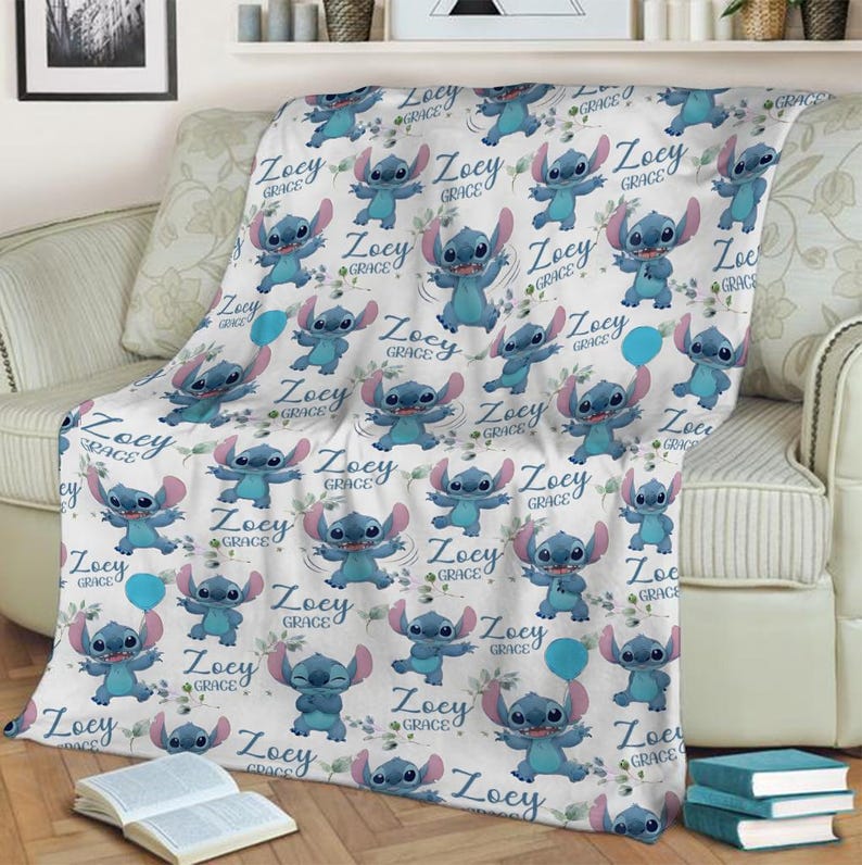 May include: A white fleece blanket featuring a repeating pattern of the blue character Stitch in various poses, interspersed with the name Zoey Grace in a blue script font and small green leaf accents, creating a playful and personalized design.