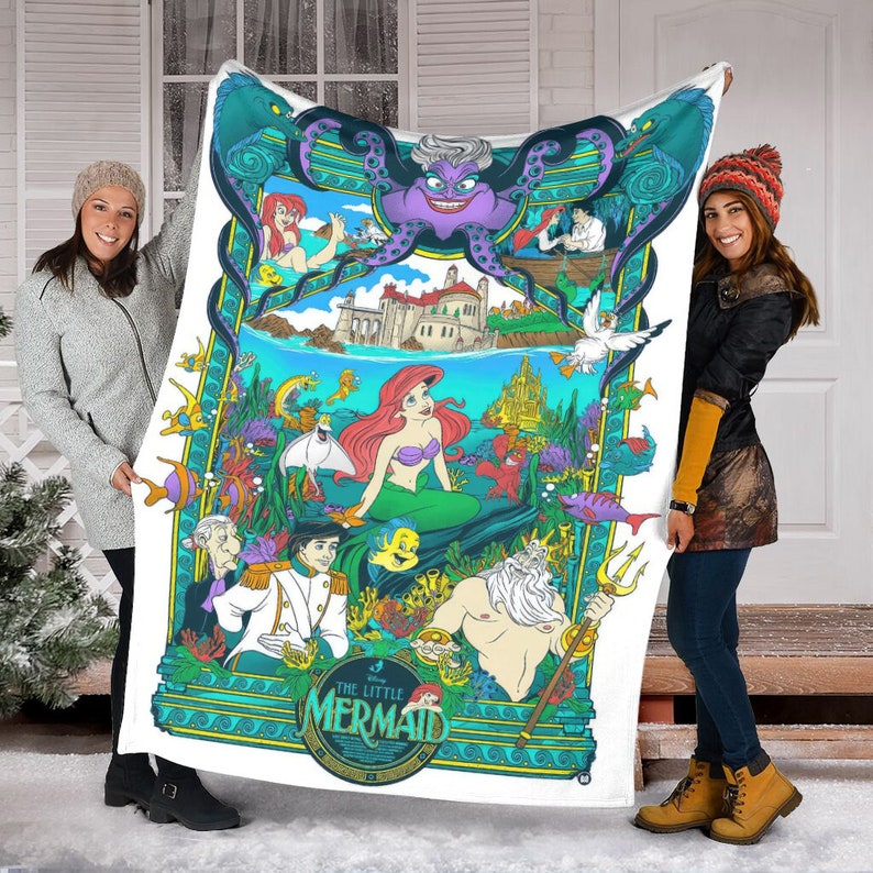 May include: A white fleece blanket featuring a colorful graphic print of The Little Mermaid characters including Ariel, King Triton, Prince Eric, and Ursula. The design includes an underwater scene with a castle, sea creatures, and the movie title.