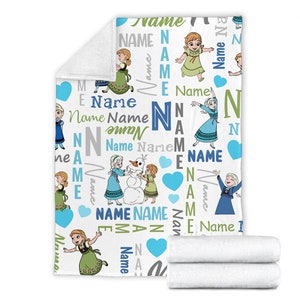 May include: A white fleece blanket featuring a repeating pattern of cartoon characters Anna, Elsa, and Olaf. The design includes the word Name in various blue, green, and gray fonts, interspersed with light blue hearts and large capital letters.