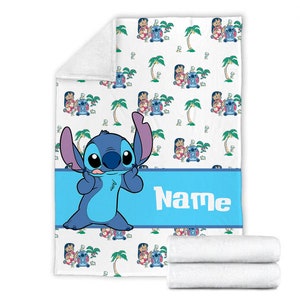 K&ouml;nnte beinhalten: Eine wei&szlig;e Fleecedecke mit einem sich wiederholenden Muster aus Lilo und Stitch sowie Palmen. Ein breites blaues horizontales Band in der Mitte zeigt das Wort Name in wei&szlig;en Buchstaben, mit einer gro&szlig;en blauen Stitch-Figur auf der linken Seite.