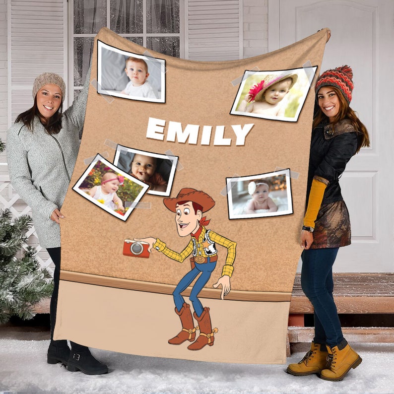 May include: A brown fleece blanket with a corkboard design featuring photos of a baby girl and the name "EMILY". A cartoon image of Woody from Toy Story is holding a camera.