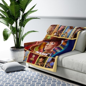 May include: A soft throw blanket featuring multiple panels of the character Woody from Toy Story in various poses. The central image shows Woody tipping his hat with the word NAME printed in white block letters below him on a dark blue background.