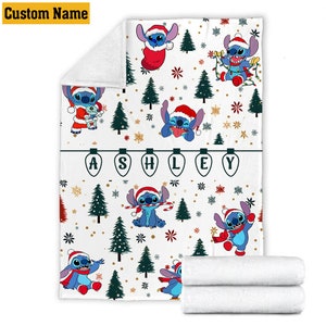 May include: A white fleece blanket featuring a repeating pattern of the blue character Stitch wearing a Santa hat, surrounded by green Christmas trees, red and gold snowflakes, and string lights. The name ASHLEY is printed inside lightbulb icons.