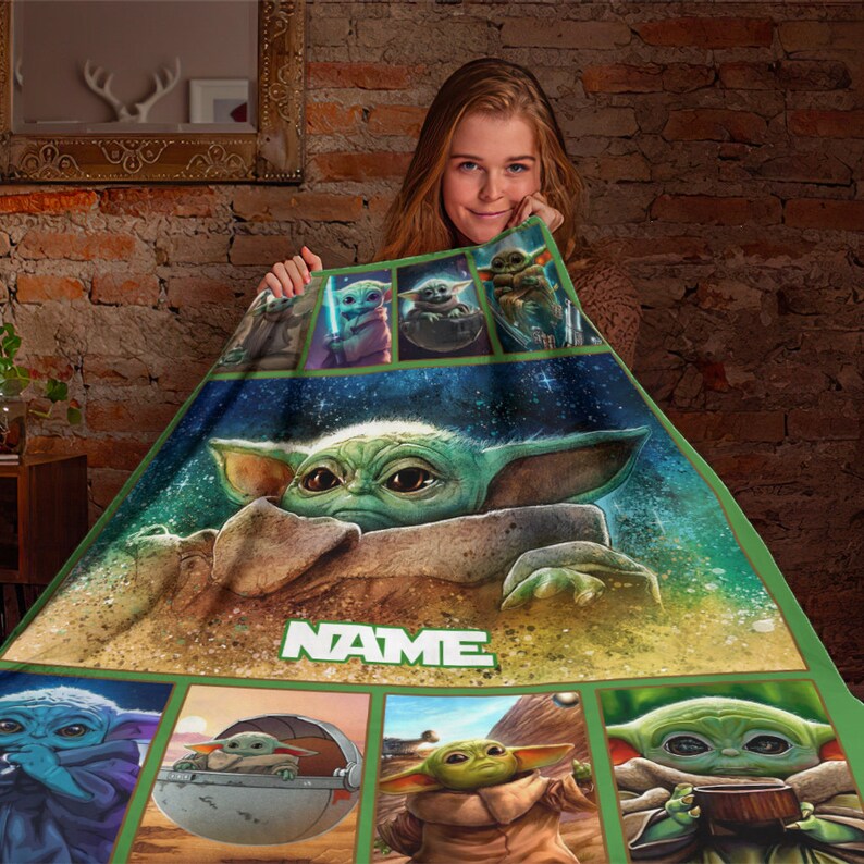 May include: A rectangular fleece blanket featuring multiple illustrations of the green character Grogu from Star Wars. The design includes a large central image of the character and smaller panels, with the word NAME printed in white block letters.
