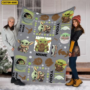 May include: A gray fleece blanket featuring a repeating pattern of the green character Grogu from Star Wars in various poses, including inside a floating pod. The design includes brown starship silhouettes, white stars, and the text CUSTOM NAME.