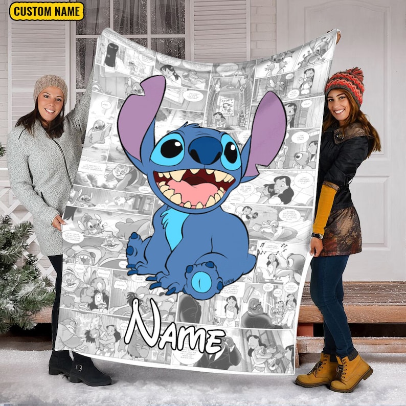 May include: A rectangular fleece blanket featuring a large, central, blue and purple cartoon character with a wide, toothy grin. The background consists of a black and white comic book panel collage. The word Name is printed in large white letters.