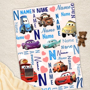 May include: A soft blanket featuring a repeating pattern of Disney Cars characters including Lightning McQueen, Mater, and Luigi. The design includes the word Name in various blue fonts, pink hearts, and the letter N on a light background.