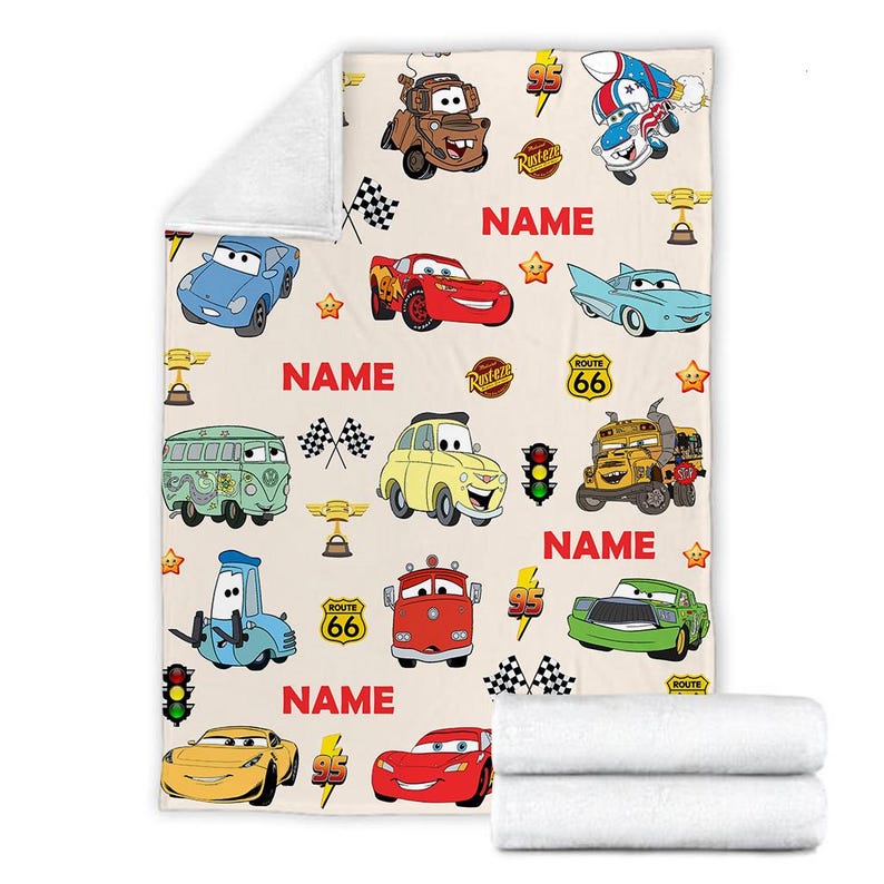 May include: A white fleece blanket with a repeating pattern of Cars characters, including Lightning McQueen, Mater, and other vehicles. The blanket features the text "NAME" and "ROUTE 66".