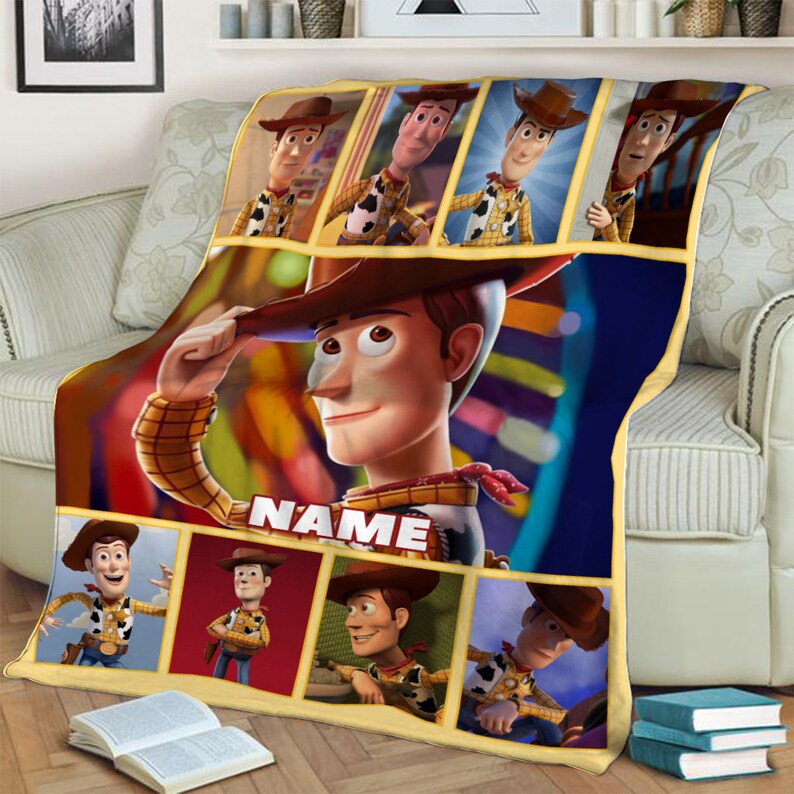 May include: A rectangular fleece blanket featuring multiple panels of the character Woody from Toy Story. The design includes a large central image of Woody tipping his hat with the word NAME printed below, surrounded by seven smaller panels.