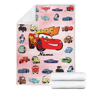 Puede incluir: Una manta de forro polar rosa con tem&aacute;tica de Cars. La manta presenta una imagen grande de Rayo McQueen, el personaje principal de la franquicia de pel&iacute;culas Cars. La manta est&aacute; decorada con una variedad de otros personajes de Cars, incluidos Mate, Doc Hudson y Sally. La manta tambi&eacute;n est&aacute; personalizada con el nombre "Name".