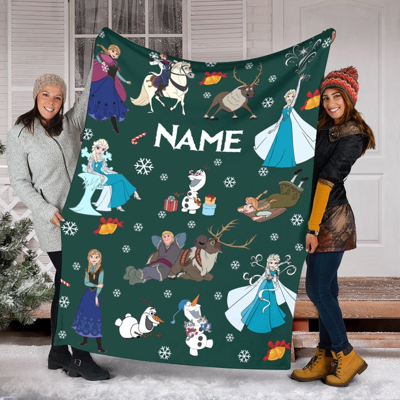 May include: A dark green fleece blanket featuring a repeating pattern of Frozen characters including Anna, Elsa, Olaf, Kristoff, and Sven, interspersed with white snowflakes, gold bells, and candy canes, with the word NAME printed in white.