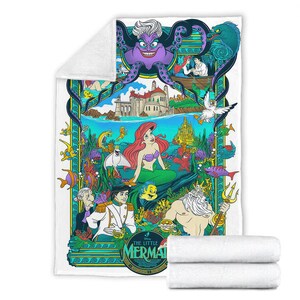 May include: A white fleece blanket featuring a colorful graphic print of The Little Mermaid characters including Ariel, Prince Eric, King Triton, and Ursula. The design includes an underwater scene with a castle, various sea creatures, and text.