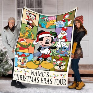 May include: A rectangular Christmas-themed blanket featuring Mickey Mouse and friends in festive attire. The blanket has a grid design with various characters, including Donald Duck and Chip and Dale. The text "NAME'S CHRISTMAS ERAS TOUR" is printed at the bottom.