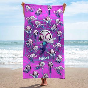 K&ouml;nnte beinhalten: Ein rechteckiges Strandtuch in leuchtendem Pink mit einem sich wiederholenden Muster aus Ghost-Spider-Figuren in verschiedenen Action-Posen vor einem hellblauen Spinnennetz-Hintergrund. Das Wort NAME ist in wei&szlig;en Blockbuchstaben mittig aufgedruckt.