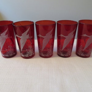 May include: Set of five red glass tumblers with a white etched design of a bird in flight.