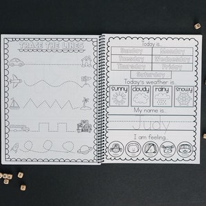 Book is opened and on the left you can see a preschool skills page that has children trace lines. The right side is a calendar with days of the week the childs name and the weather and emotions.