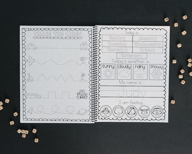 Book is opened and on the left you can see a preschool skills page that has children trace lines. The right side is a calendar with days of the week the childs name and the weather and emotions.