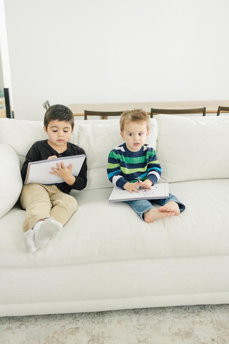 two young boys holding personalized coloring books.