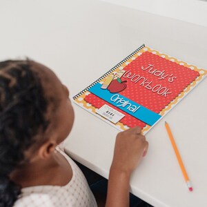 Child working on their personalized workbook. The child is filling out the calendar page and tracing their name.