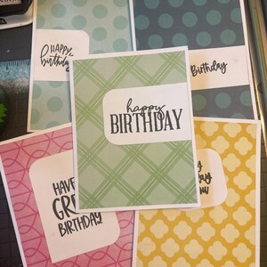 Könnte beinhalten: Fünf rechteckige Grußkarten mit verschiedenen Mustern und Farben. Die Karten zeigen gedruckten Text, darunter "Happy Birthday" und "Have a Great Birthday", auf weißen, rechteckigen Etiketten mit abgerundeten Ecken auf gemustertem Hintergrund.