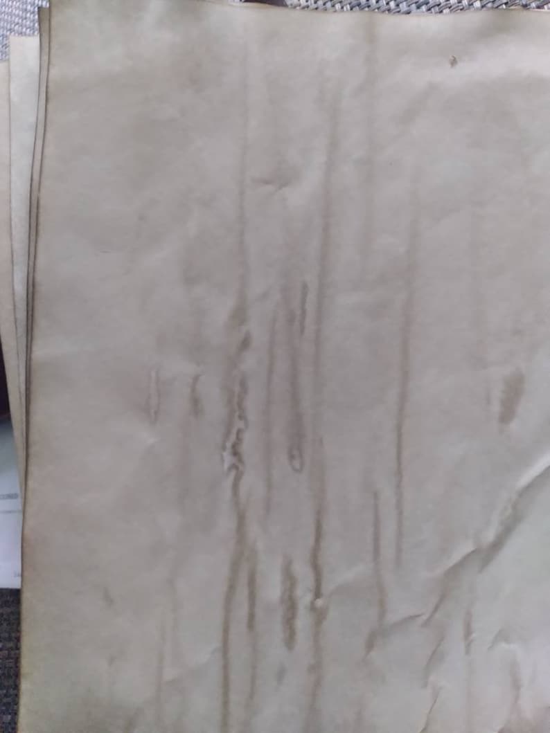 K&ouml;nnte beinhalten: Ein Stapel gealterter, cremefarbener Papierb&ouml;gen. Das Papier hat ein strukturiertes Aussehen mit vertikalen Streifen in einem dunkleren, br&auml;unlichen Farbton, was auf Wassersch&auml;den oder Flecken hindeutet. Die R&auml;nder des Papiers weisen leichte Verf&auml;rbungen auf.
