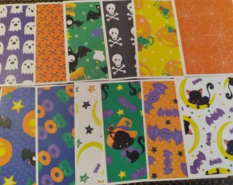 May include: A collection of Halloween-themed cards with various patterns. Designs include ghosts, bats, skulls, pumpkins, spiderwebs, and cats. The cards feature a mix of colors, including purple, orange, green, yellow, and black, creating a festive and spooky aesthetic.