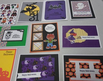 May include: A collection of handmade Halloween greeting cards. Designs include pumpkins, ghosts, bats, witches, and other spooky characters. Each card features unique artwork and the words "Happy Halloween" or "Have a Spooky Halloween".
