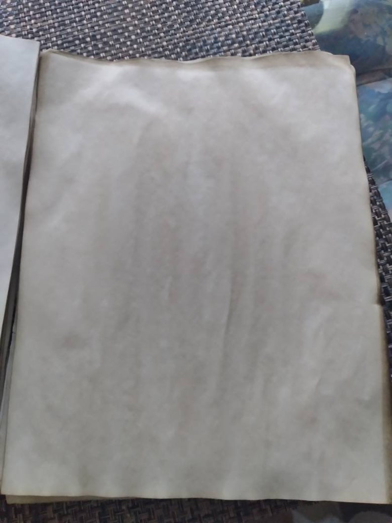 K&ouml;nnte beinhalten: Ein Stapel gealterter, cremefarbener Papierb&ouml;gen. Das Papier hat eine leicht strukturierte Oberfl&auml;che mit subtilen Farbvariationen, und die R&auml;nder weisen ein dunkleres, gealtertes Aussehen auf. Das Papier ist wahrscheinlich f&uuml;r k&uuml;nstlerische oder dekorative Zwecke bestimmt.