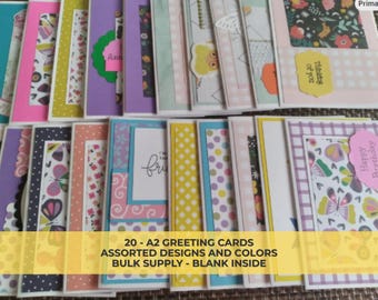May include: A collection of assorted A2 greeting cards in various colors and designs. The cards feature patterns like polka dots, floral, and butterflies. Text on the cards includes "Thinking of you", "Happy Birthday", and "fri". The cards are blank inside.