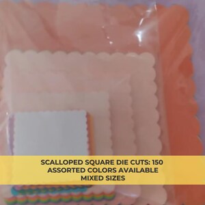 May include: A package of assorted die cuts in various pastel colors, including pink, peach, and lavender. The die cuts are square with scalloped edges. Text on the packaging reads: SCALLOPED SQUARE DIE CUTS: 150 ASSORTED COLORS AVAILABLE MIXED SIZES.
