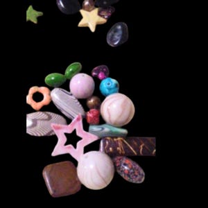 May include: A selection of colourful beads in various shapes and sizes. Includes star, oval, and round beads in shades of pink, green, brown, and blue. Some beads have patterns or textures.