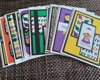 May include: A collection of Halloween-themed greeting cards. The cards feature various designs, including candy, polka dots, and the text "Trick or Treat." The color palette includes orange, purple, green, and yellow.