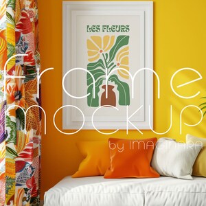May include: A framed art print with the text "LES FLEURS" in green and yellow. The artwork features a floral design in a brown vase. The print is displayed on a yellow wall above a white sofa with orange and yellow pillows.