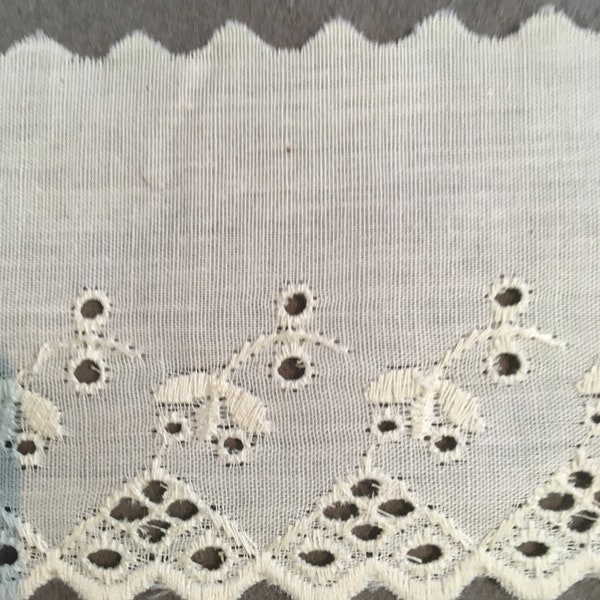 Ecru eyelet lace with embroidered floral motif and geometric edge. 3 1/4" wide. Lots of 17 1/2 yards