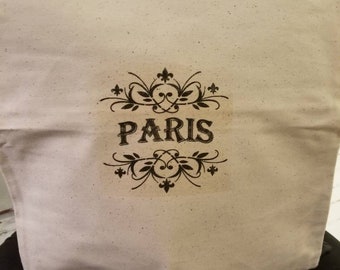 May include: A white canvas tote bag with the word "PARIS" printed in black with a decorative design.