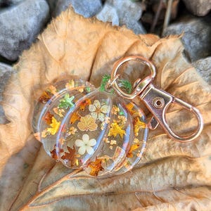 Autumn bag charm, pumpkin bag charm, rose gold coloured clip, pressed flowers pumpkin charm, pumpkin zip charm, fall bag charm, pumpkin with pressed flowers, real flowers bag charm, resin bag charm, pumpkin keyring, pressed flower pumpkin keyring, zip charm, Halloween bag charm, Halloween accessories, autumn accessories, pressed flower pumpkin charm